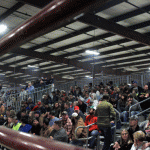 a crowd on stadium bleachers at an indoor rodeo