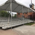 Bleachers on Demand sets up rental bleachers and a tent to make event seating more comfortable.